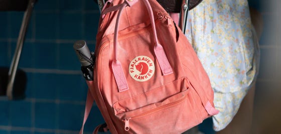 pink backpack hanging on chair