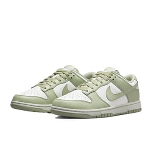 Nike Dunk Low shoes in light green and white, featuring a classic low-top design with a leather upper, perforated toe box, and iconic Swoosh logo. They have a stitched rubber outsole for durability and traction.