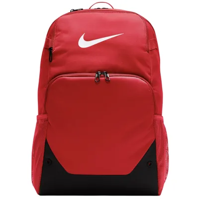 A red Nike backpack featuring a large front zippered compartment, side mesh pockets, and a black bottom panel, prominently displaying the Nike logo on the top.
