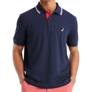 A navy blue polo shirt with a red button placket, featuring a white emblem on the chest, and a striped collar with blue, red, and white accents, paired with pink shorts.