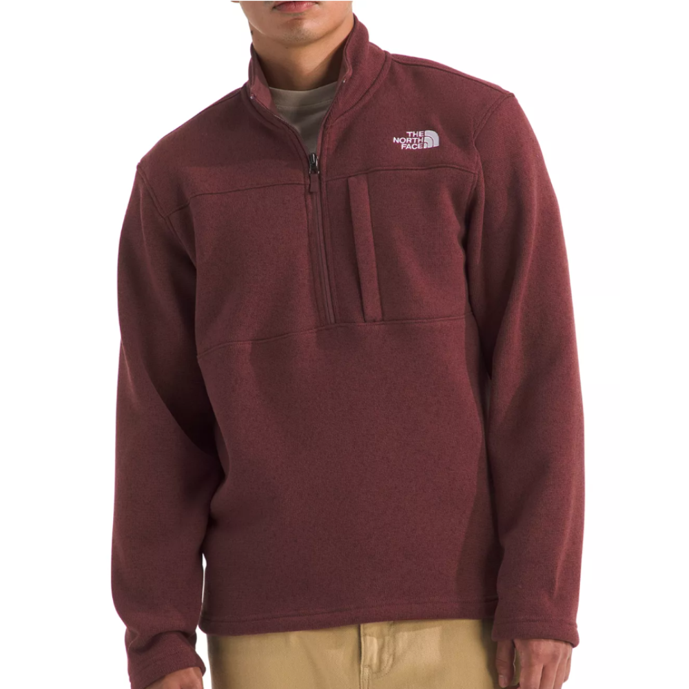 A maroon quarter-zip fleece pullover by The North Face with a chest pocket, worn over a beige shirt.