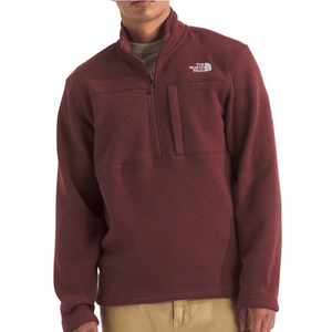 A maroon quarter-zip fleece pullover by The North Face with a chest pocket, worn over a beige shirt.
