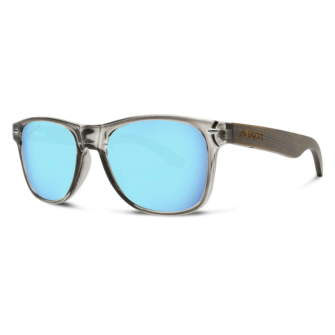 Sunglasses with a transparent frame, blue mirrored lenses, and wooden-textured arms with \“Abaco\“ branding.