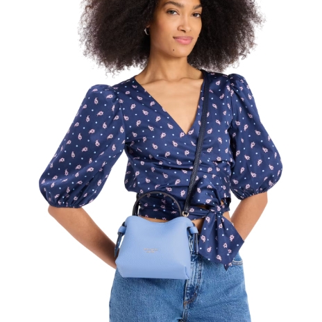 A light blue mini tote with a compact, structured design and dual top handles, featuring an adjustable crossbody strap.