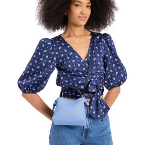 A light blue mini tote with a compact, structured design and dual top handles, featuring an adjustable crossbody strap.