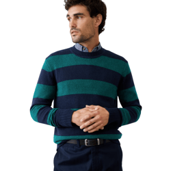 A man is wearing a navy and green striped sweater over a button-up shirt, paired with dark pants and a black belt.