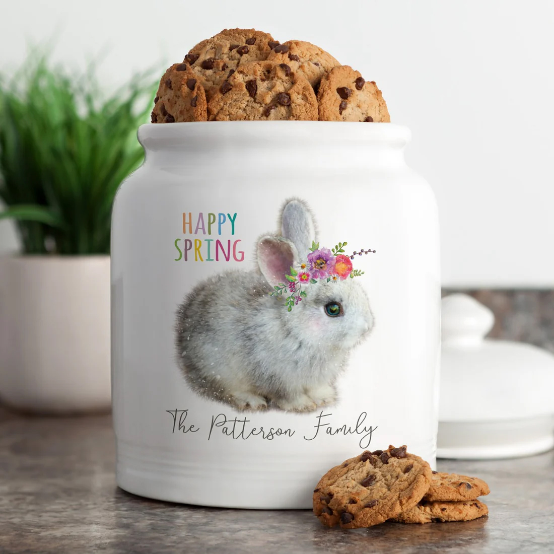 10\“ personalized ceramic cookie jar featuring a fluffy bunny adorned with a floral crown, alongside the text \“Happy Spring\“ and \“The Patterson Family,\“ filled with chocolate chip cookies.