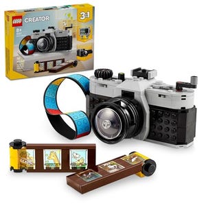 A LEGO Creator set designed to resemble a retro camera, including a film strip with illustrated scenes and a camera strap.