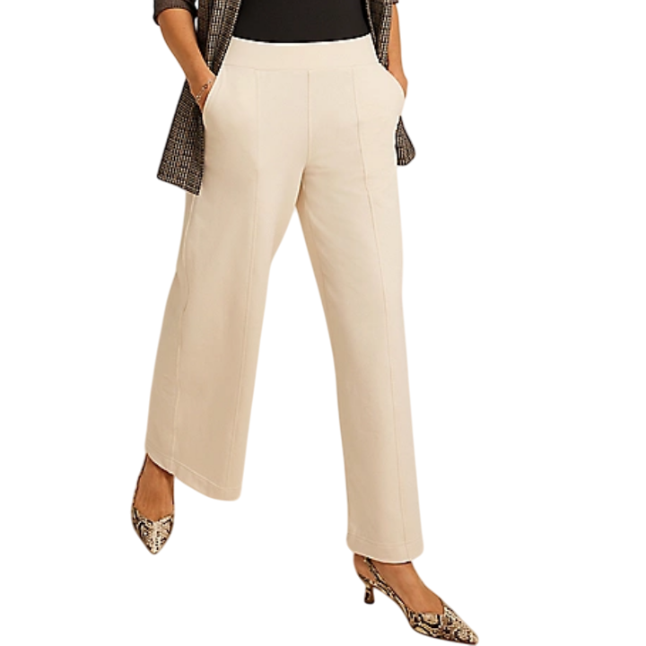 Wide-leg cream trousers paired with a black top, checkered blazer, and snakeskin-patterned heels.
