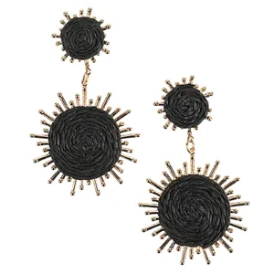Black woven fabric earrings with gold sunburst accents, featuring two circular components connected by small gold links.
