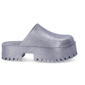 A single glittery silver platform sandal with a jagged sole.