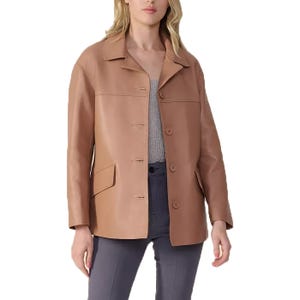 Tan leather jacket with a classic collar, button closure, and front pockets, worn over a gray blouse and dark pants.