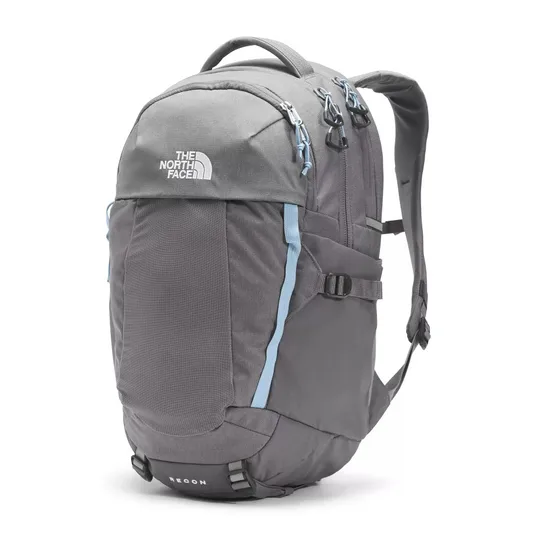 A gray North Face Recon backpack with light blue accents, featuring multiple compartments, adjustable straps, and a top handle.