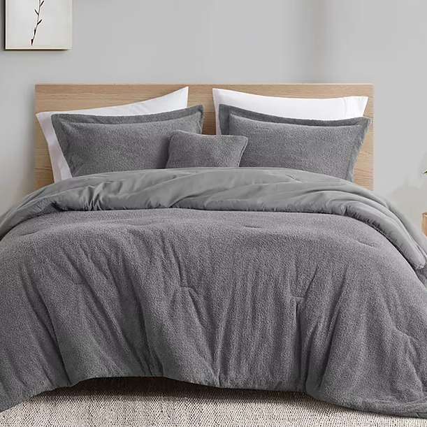 A plush gray comforter set with matching shams, featuring a textured design for added visual interest. The set creates a calming and cozy bedroom atmosphere.