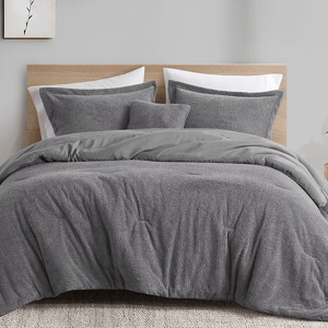 A plush gray comforter set with matching shams, featuring a textured design for added visual interest. The set creates a calming and cozy bedroom atmosphere.