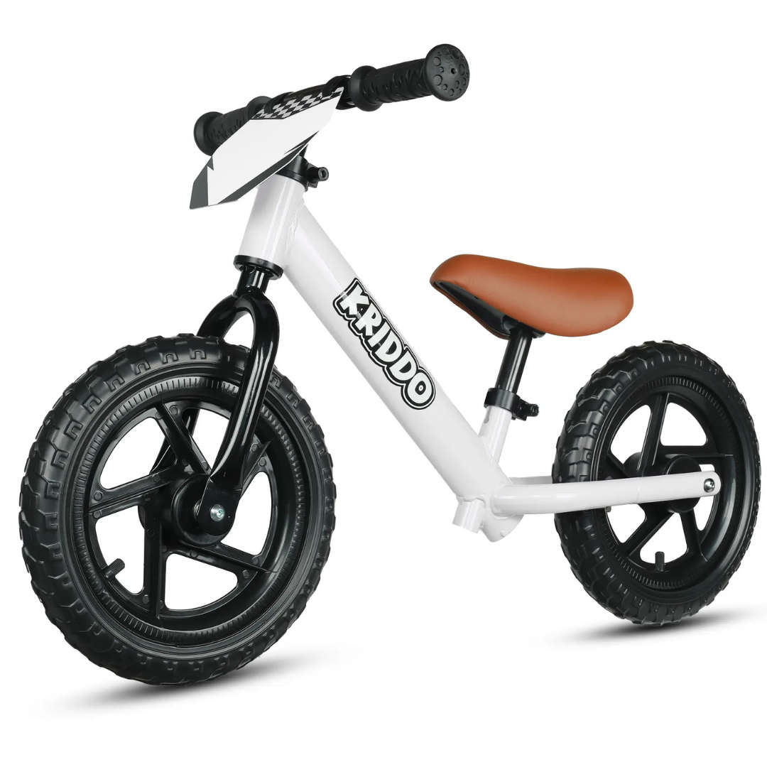A white balance bike with black wheels and a brown seat, featuring the brand name \“KRIDDO\“ on the frame.