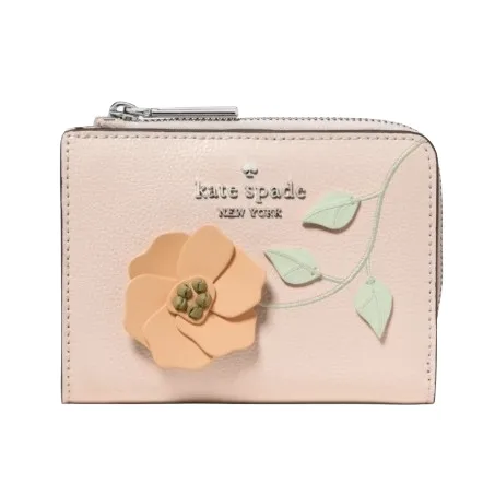 A small, pastel pink wallet with a zip closure, featuring the \“kate spade new york\“ logo and an embossed floral design with a peach flower and green leaves.