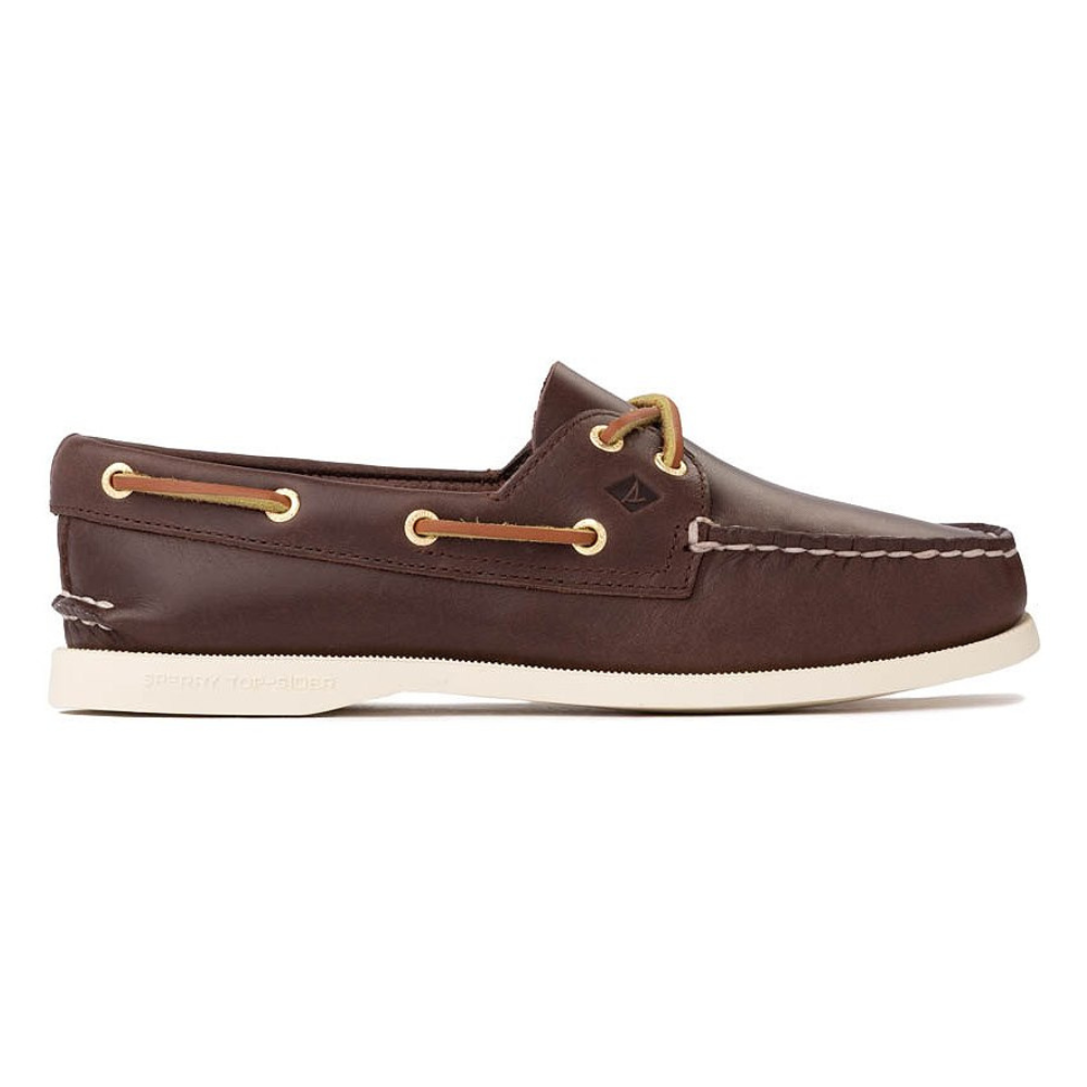 Brown leather boat shoe with white sole, featuring tan laces threaded through gold eyelets, and a moccasin-style front seam.