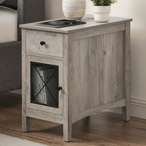 Light gray wooden nightstand with a drawer and mesh-front cabinet, featuring black knobs. Items on top include a plant in a white pot and a tablet.
