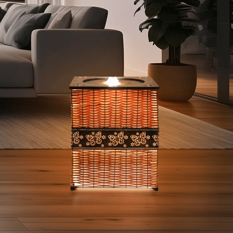 A woven rectangular lamp with floral patterns emits a warm glow, placed in a modern living room setting with a sofa, rug, and potted plant.