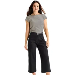 A woman is wearing a short-sleeve, striped top and black wide-leg pants with a belt.