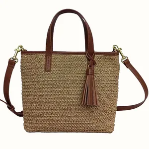 Rectangular woven tote with brown leather trim, detachable shoulder strap, and tassel embellishment.