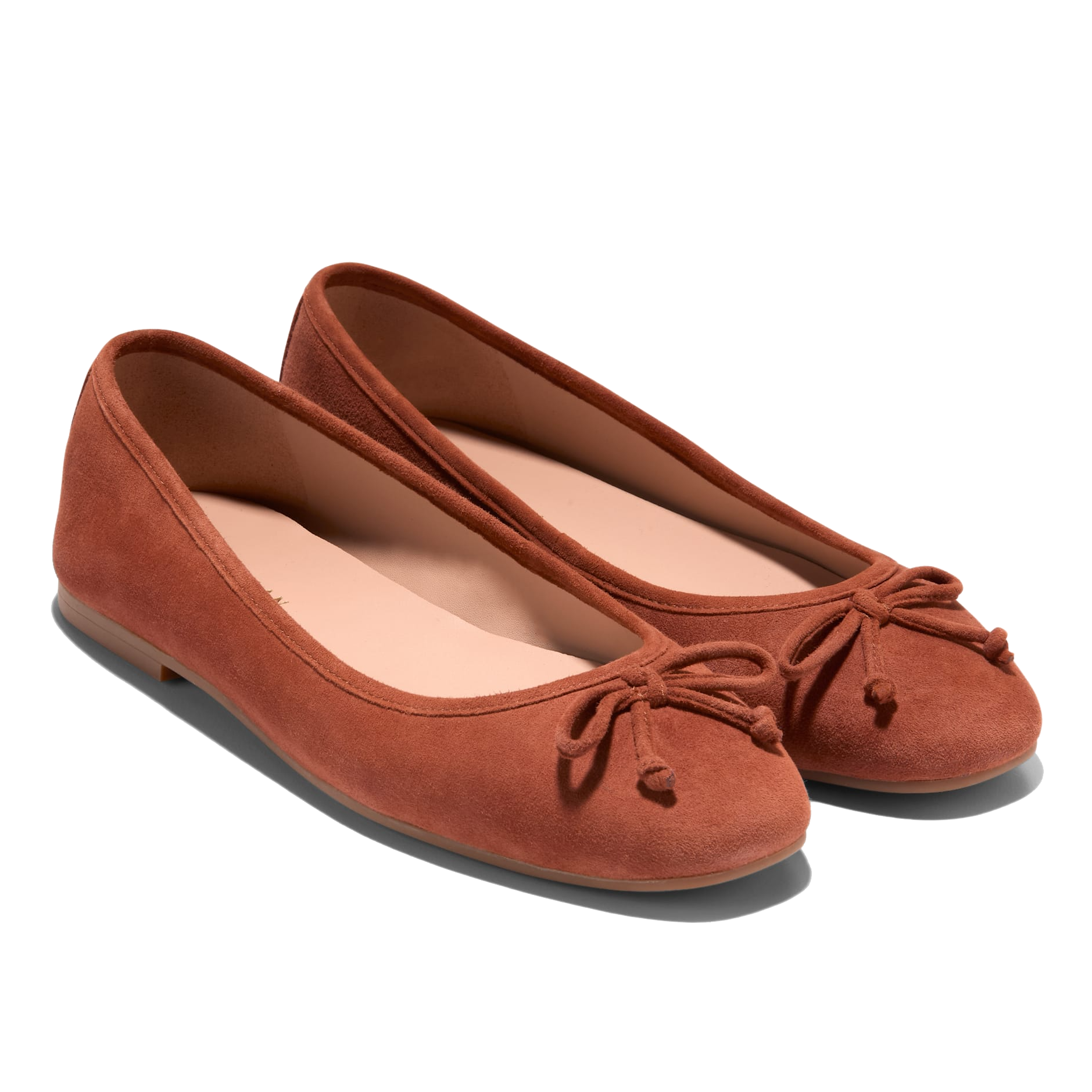 Cole Haan soft suede ballet flats in a warm brown color with a rounded toe design, featuring a subtle bow detail on top and a low heel for comfort.