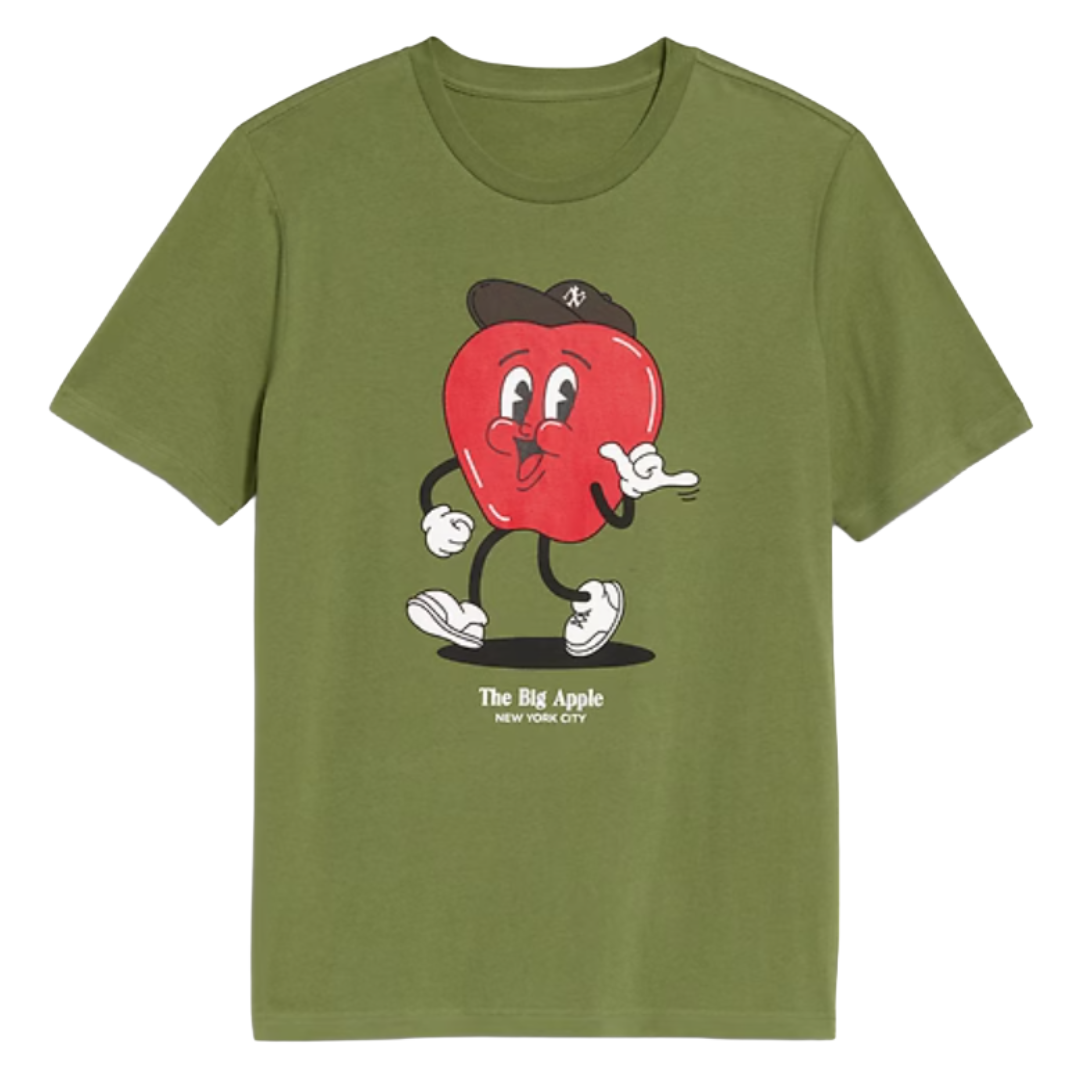 A green t-shirt featuring a cartoon red apple with arms and legs, wearing a hat and sneakers, with the text \“The Big Apple New York City\“ underneath.