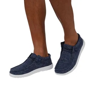 A pair of casual blue slip-on shoes with white soles, featuring a textured fabric design and lace detailing.