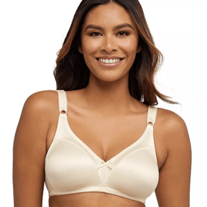 A woman is wearing a beige bra with wide straps and a subtle design, featuring a small bow at the front. The bra appears to be wireless and designed for comfort.