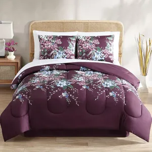 A floral-patterned bedding set with deep purple tones, including a comforter and pillowcases.
