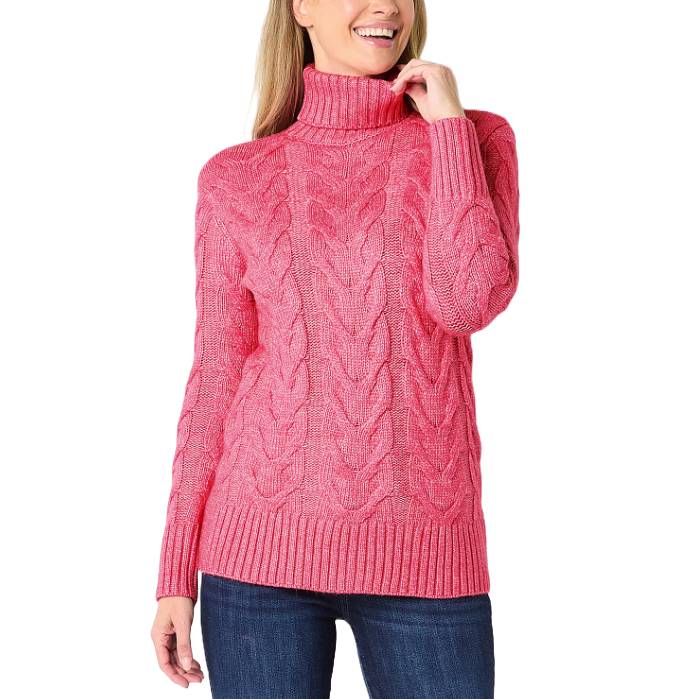 A bright pink cable knit turtleneck sweater paired with dark blue jeans.