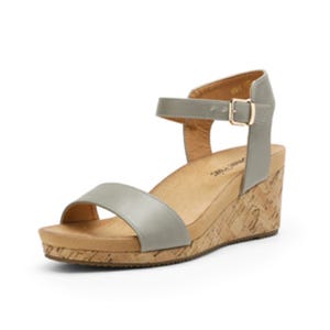 A gray wedge sandal with a cork sole and ankle strap featuring a buckle.