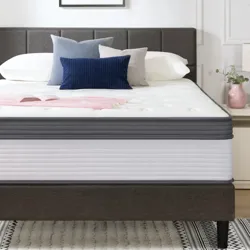 A modern bedroom setup features a bed with a plush mattress, several decorative pillows, and minimalistic bedside tables with lamps. A simple abstract painting adorns the wall above.