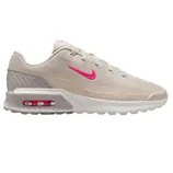A beige Nike sneaker featuring a pink Swoosh and Air Max cushioning.