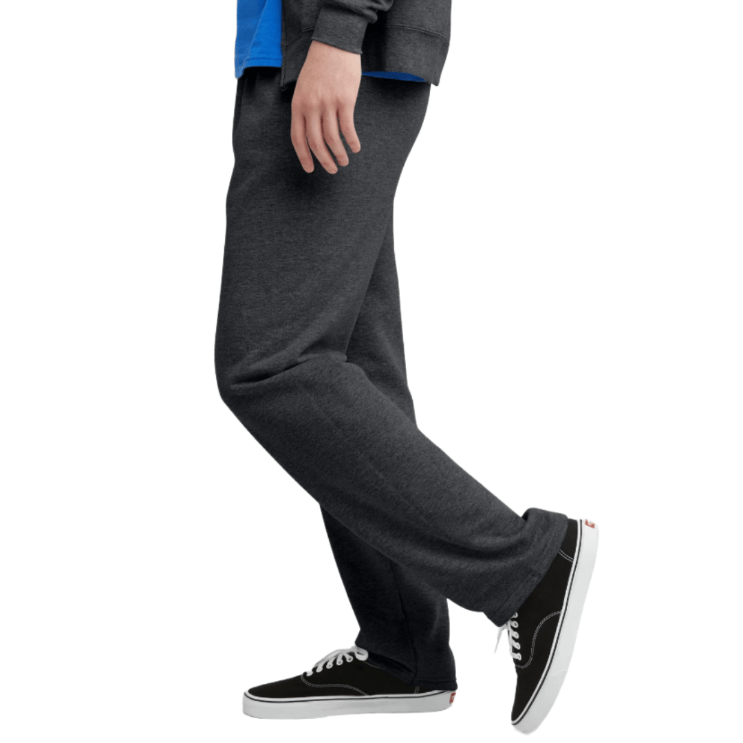 A person is wearing dark gray sweatpants and black sneakers with white soles.