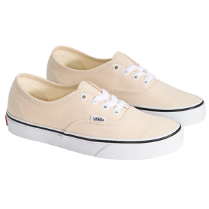 A pair of beige Vans sneakers with white laces, featuring a white sole with a black stripe and the Vans logo on the side.