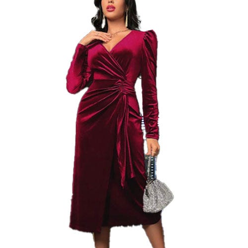 A woman wearing a burgundy velvet wrap dress with long sleeves and a ruched design, paired with a silver, sparkly textured handbag.