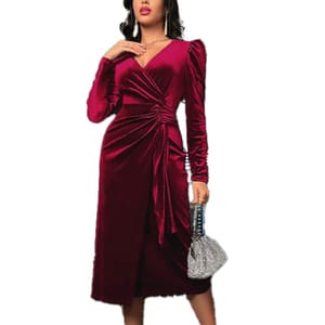 A woman wearing a burgundy velvet wrap dress with long sleeves and a ruched design, paired with a silver, sparkly textured handbag.