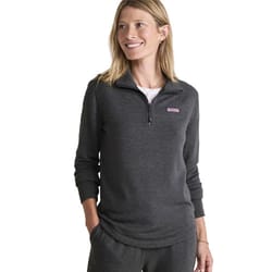 A woman wearing a dark gray half-zip pullover with a small logo on the front, paired with matching pants.