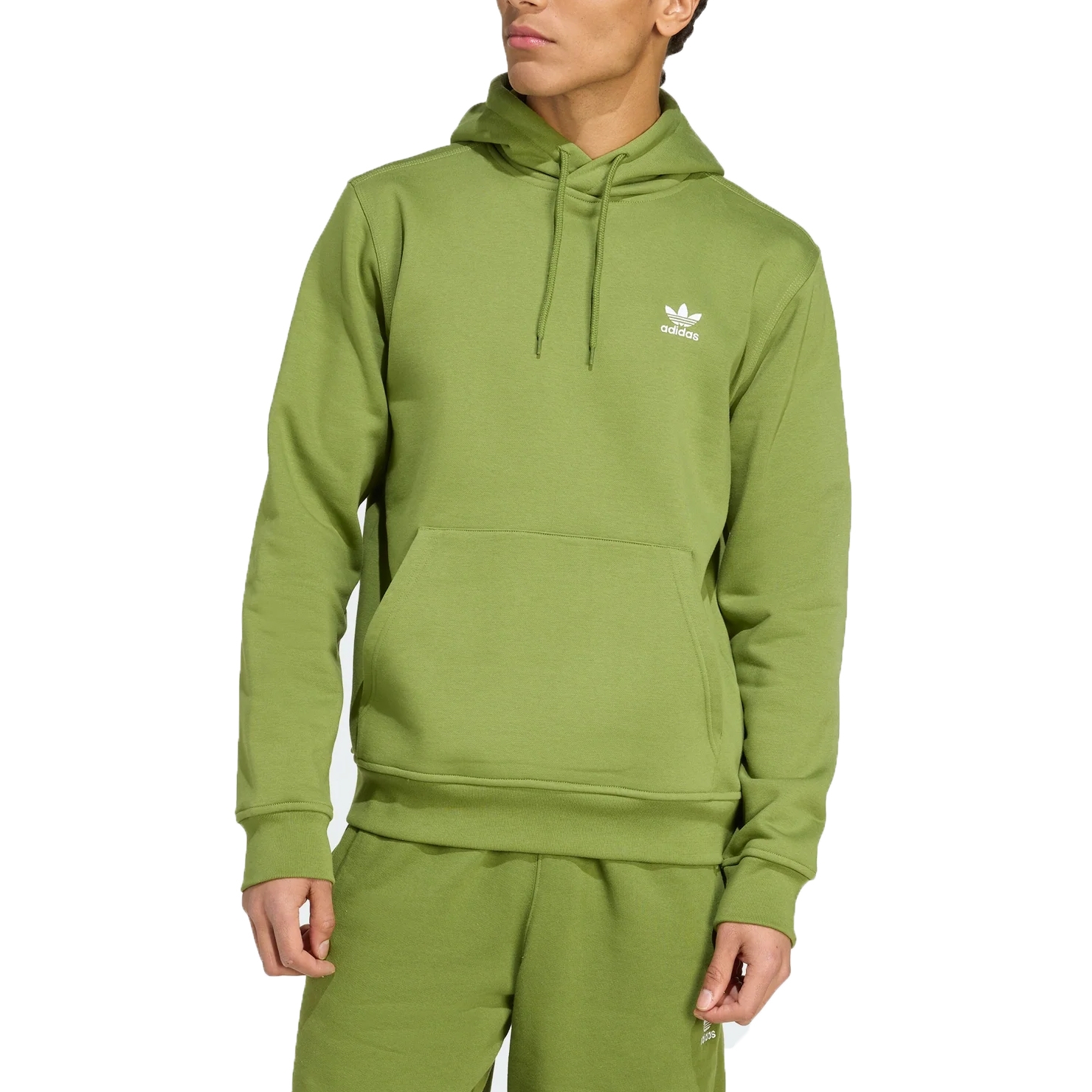 A person is wearing a green Adidas hoodie featuring a white logo on the chest, paired with matching green sweatpants.