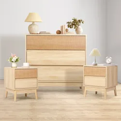 A minimalist furniture set with a tall dresser and two side tables in light wood, featuring grooved accents. Accessories include lamps, books, and decorative items.