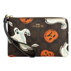 A Coach wristlet with a Halloween theme featuring ghost and pumpkin illustrations.