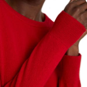 A vibrant red long-sleeve sweater with ribbed cuffs.