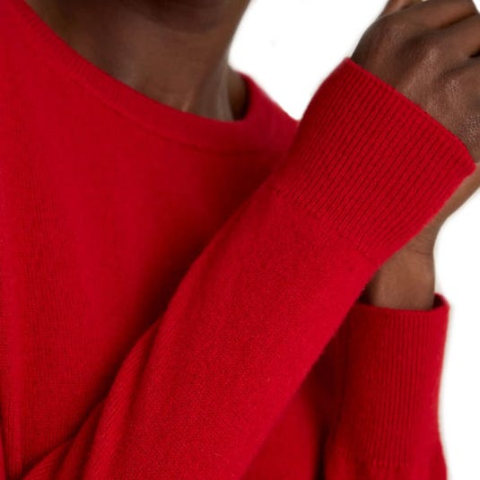 A vibrant red long-sleeve sweater with ribbed cuffs.