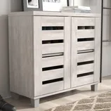Light-toned wooden shoe cabinet with slatted doors, set against a wall, next to a patterned rug.