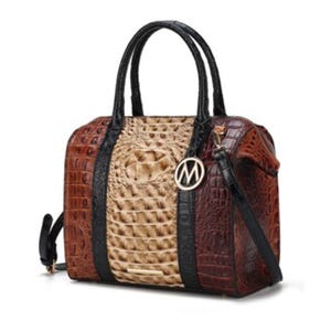 A handbag featuring a crocodile texture with a combination of brown and beige colors, black handles, and a detachable shoulder strap, adorned with a metallic circular charm.