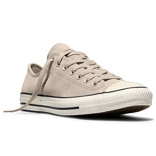 A beige low-top sneaker with a classic design featuring canvas material, white rubber toe cap, and black stripe details.