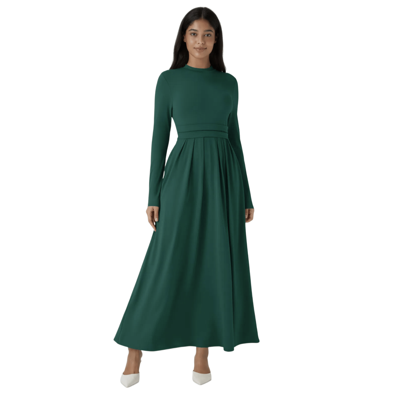 A woman wears a long-sleeve, floor-length green dress with a fitted bodice and pleated skirt, paired with white pointed-toe shoes.