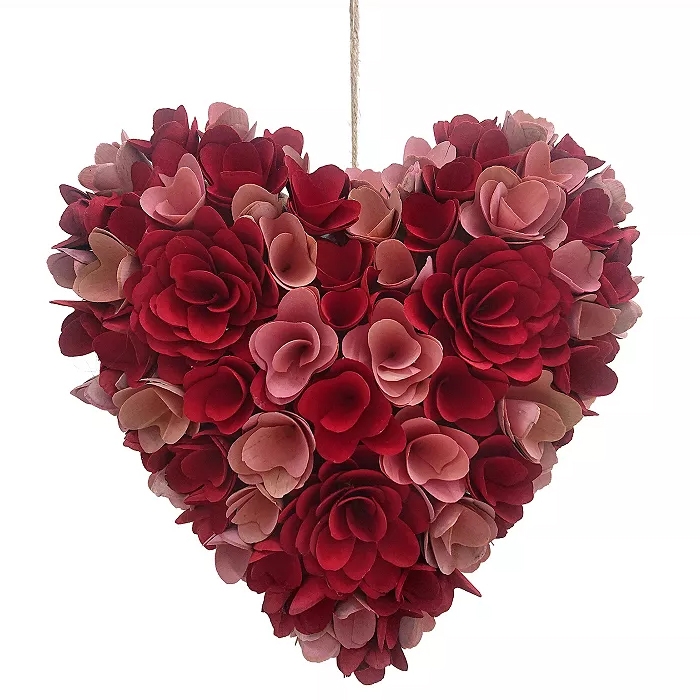 A heart-shaped wreath made of red and pink wood curls in a floral design, approximately 14 inches wide, with a string for hanging.